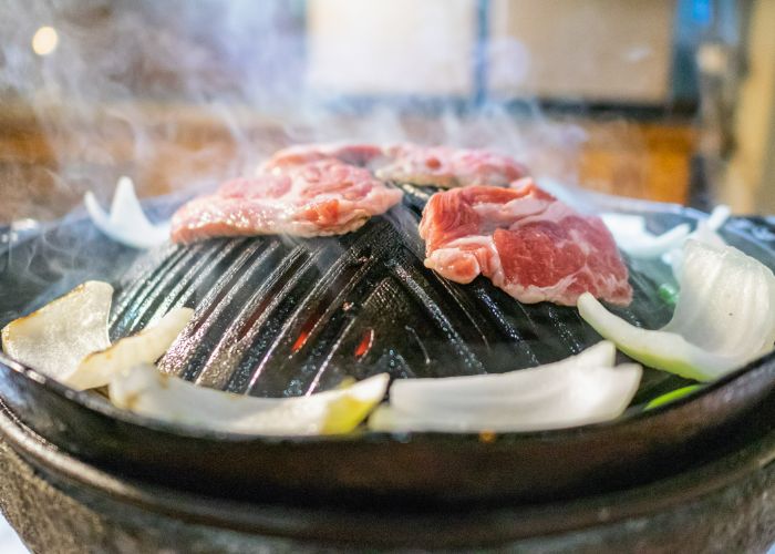 Jingisukan BBQ, a Sapporo specialty of grilled mutton and vegetables on a grill with a raised center.
